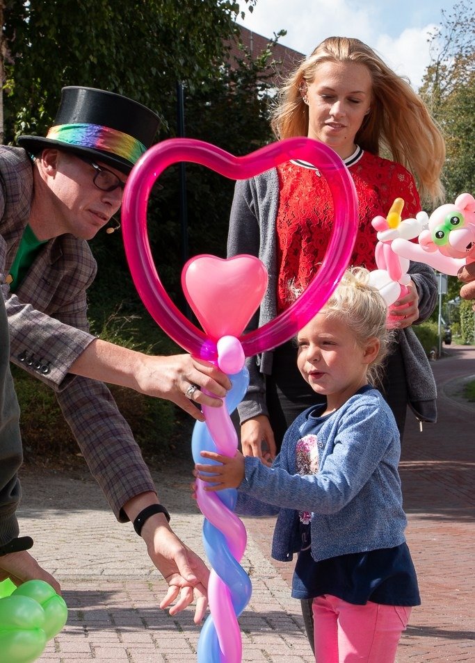 Ballonnenkunstenaar maakt een hartballon tijdens een kinderfeestje