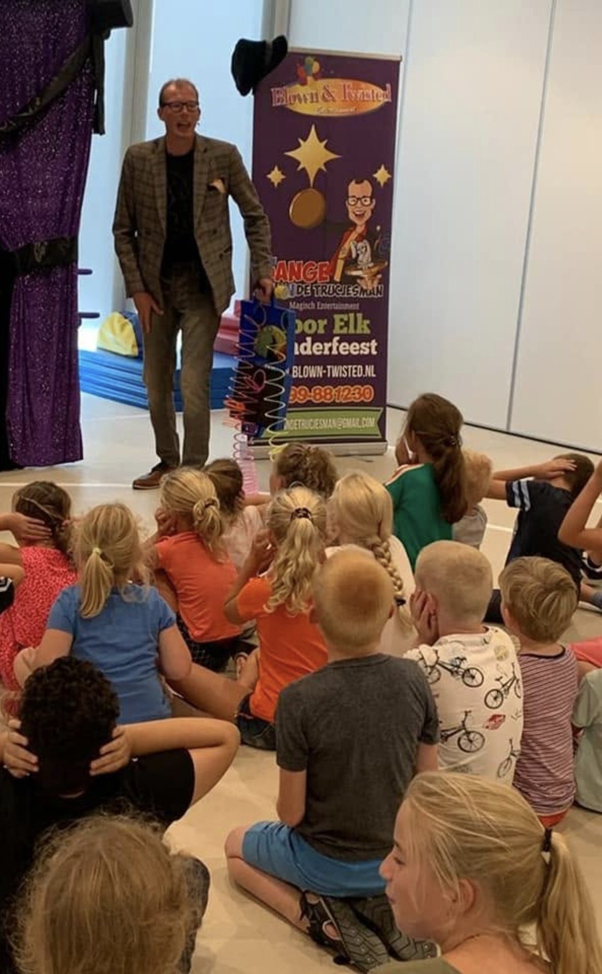 Kinderen kijken vol verwondering naar de goochelshow tijdens Ballonnenpret